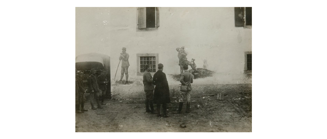 Fotografo non identificato, ufficiali guardano un murale con "Il Primo saluto" e "Il più bel Zappatore della Compagnia", 1919, gelatina ai sali d'argento, 12x17 cm, PV000344