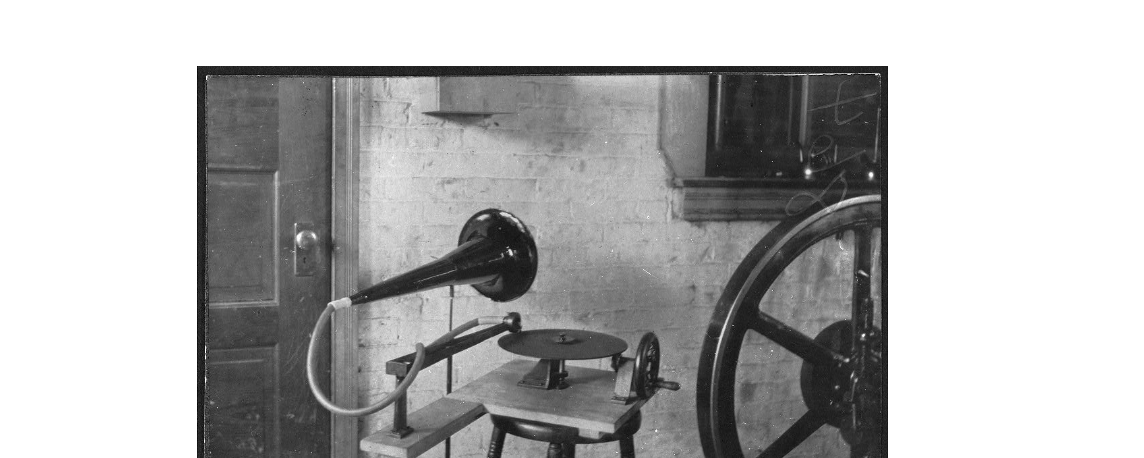 Autore non identificato, Uno dei primi grammofoni accostato a una grande ruota meccanica, 1888, fotografia in bianco e nero, Library of Congress - Washington (DC).